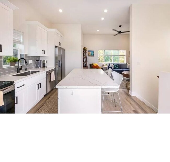 View into the kitchen and living space from the open patio doors. - 3355 Lloyd St