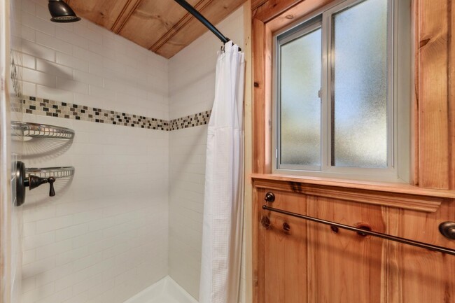 Bathroom with walk in shower and stacked washer dryer - 1139 Craig Ave