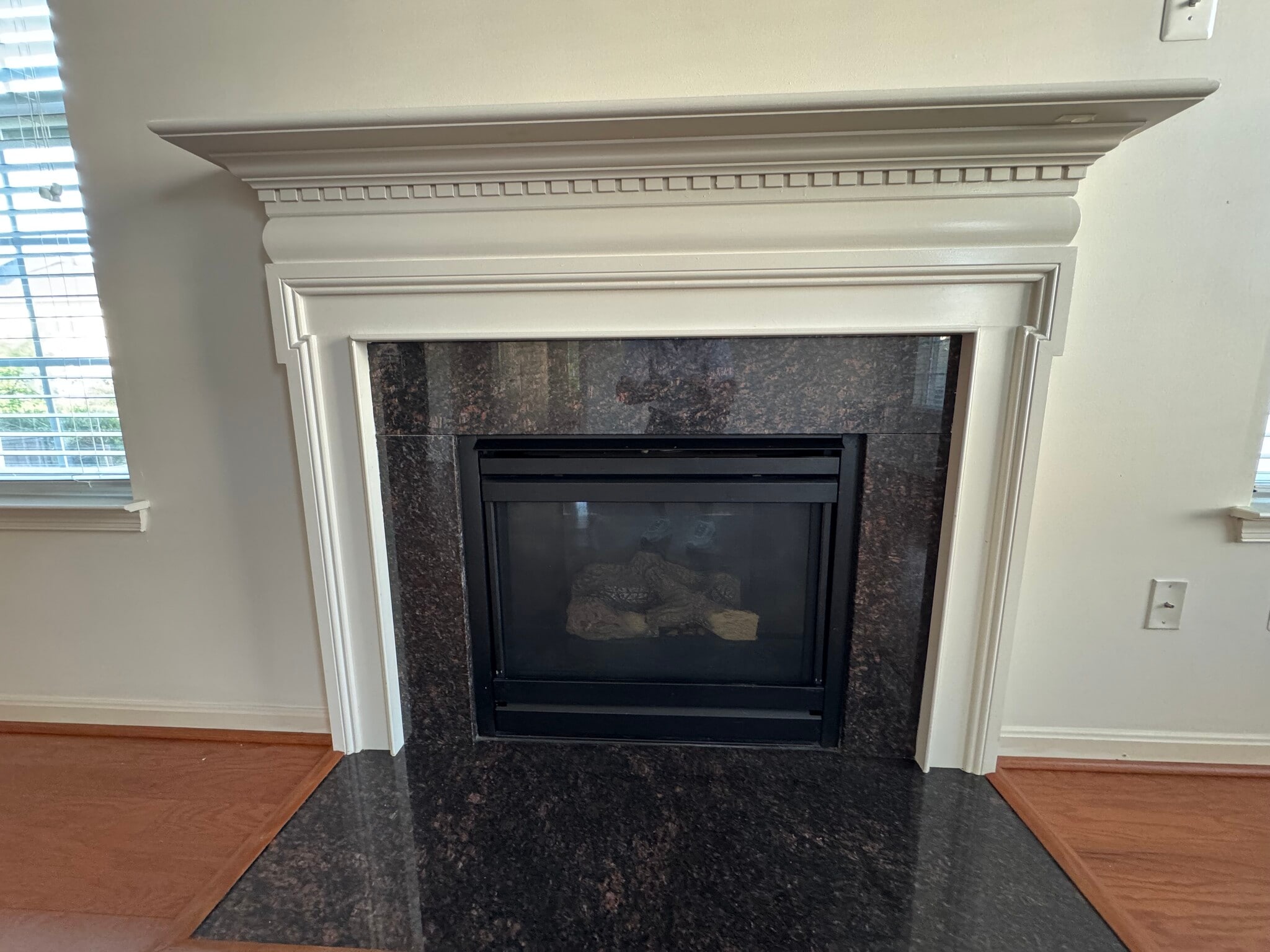 The great room has a gas fire place, custom mantel and granite surround. - 44520 Gray Wolf St