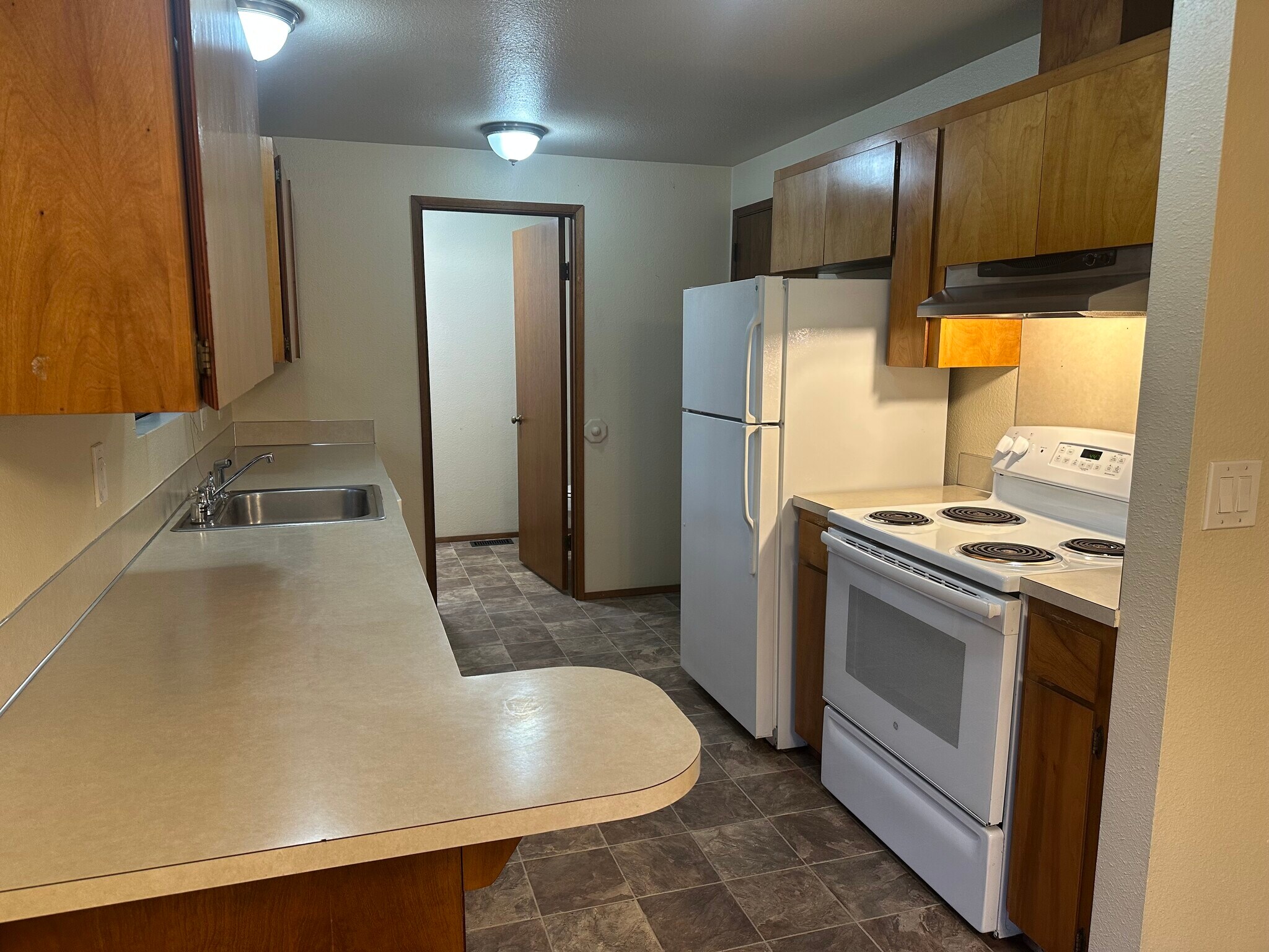 Kitchen leading into half bathroom and utility area with hook ups for washer and dryer - 6439 Armar Rd