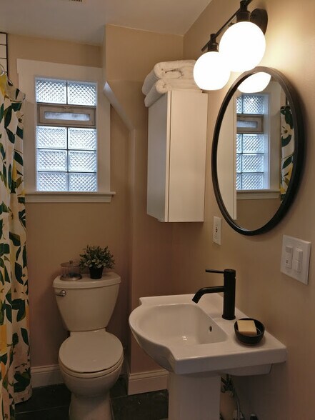 Completely remodeled bathroom features a deep soaking tub and a tub-to-ceiling tile surround. - 2526 NE Taylor St