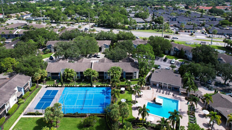 Discover the vibrant community of Harper Grand Apartments from above. Enjoy amenities like our pristine swimming pool and tennis courts, surrounded by lush greenery and modern apartment homes. - Harper Grand