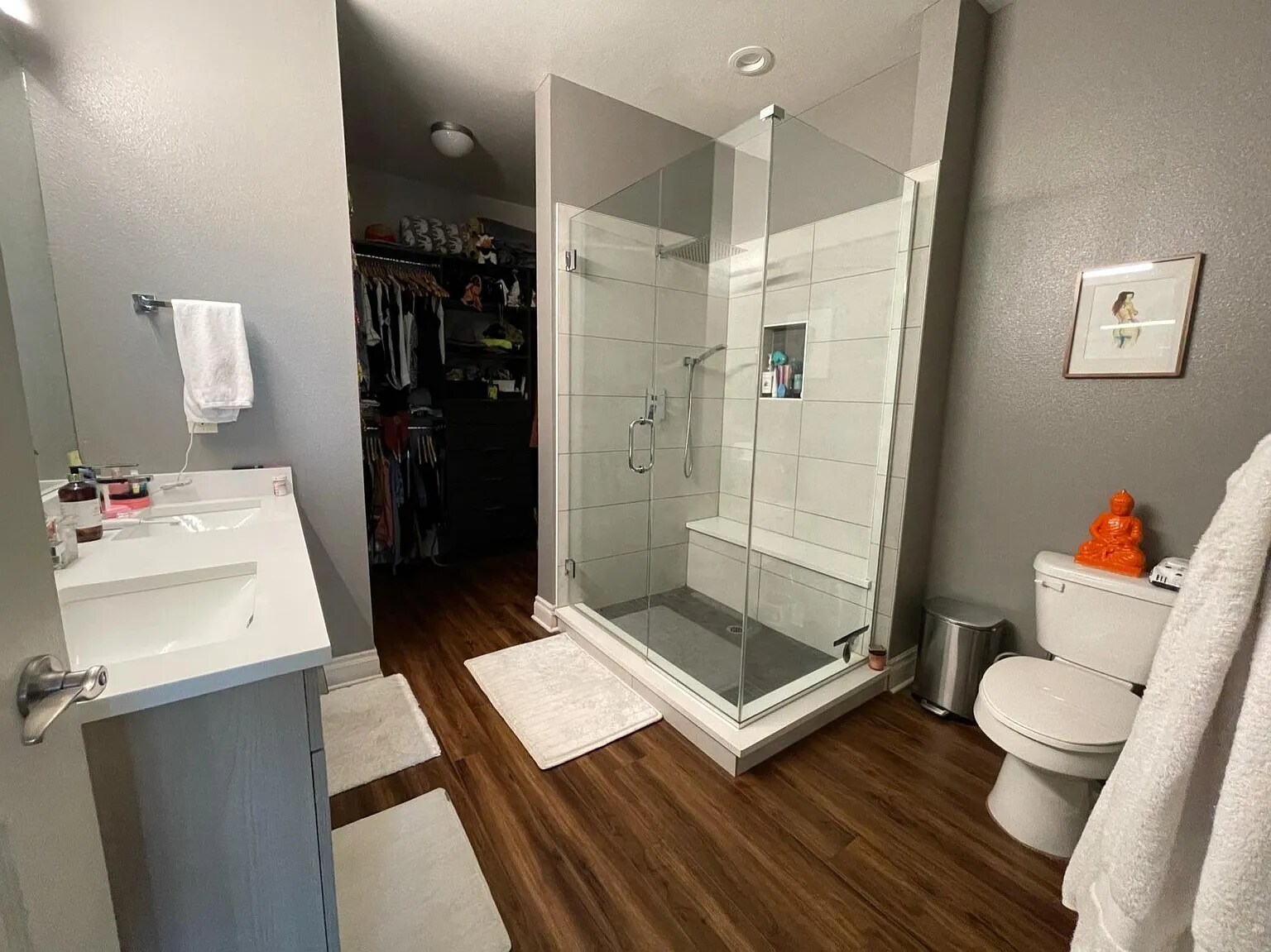 Remodeled primary bathroom with double vanity, frameless shower with seat, rain head shower and hose - 1700 N Emerson St