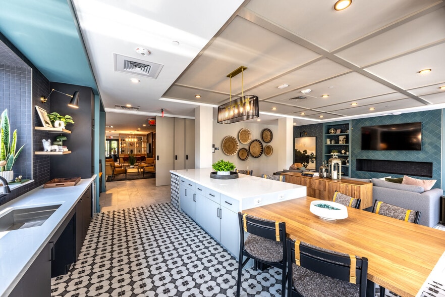Resident clubhouse lounge featuring a kitchen island and bar seating - The Elmwood