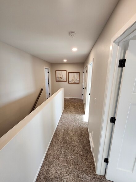 Hallway from upstairs bath looking toward bedrooms one, two and laundry (on right) & Primary (left) - 5312 Welder Ave