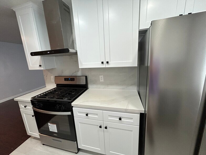 Kitchen - Stainless steel hood, Stove and refrigerator - 325 S Doheny Dr