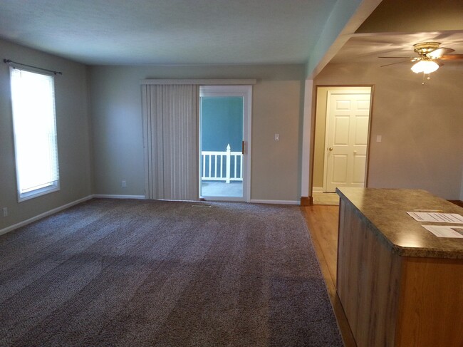 Living room view to balcony and front foyer entrance. - 2107 Glouchester Dr