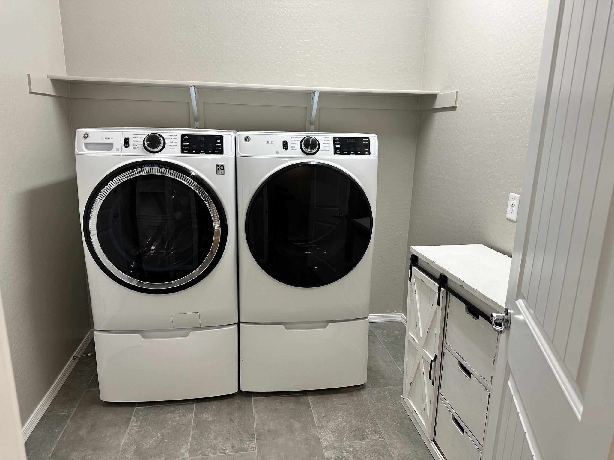 Laundry room with washer/dryer and two white cabinets - 6272 Barn Owl Ave