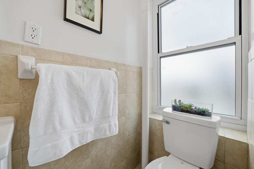 Primary bathroom featuring tiled walls and a stand-in shower. - 555 Broadway