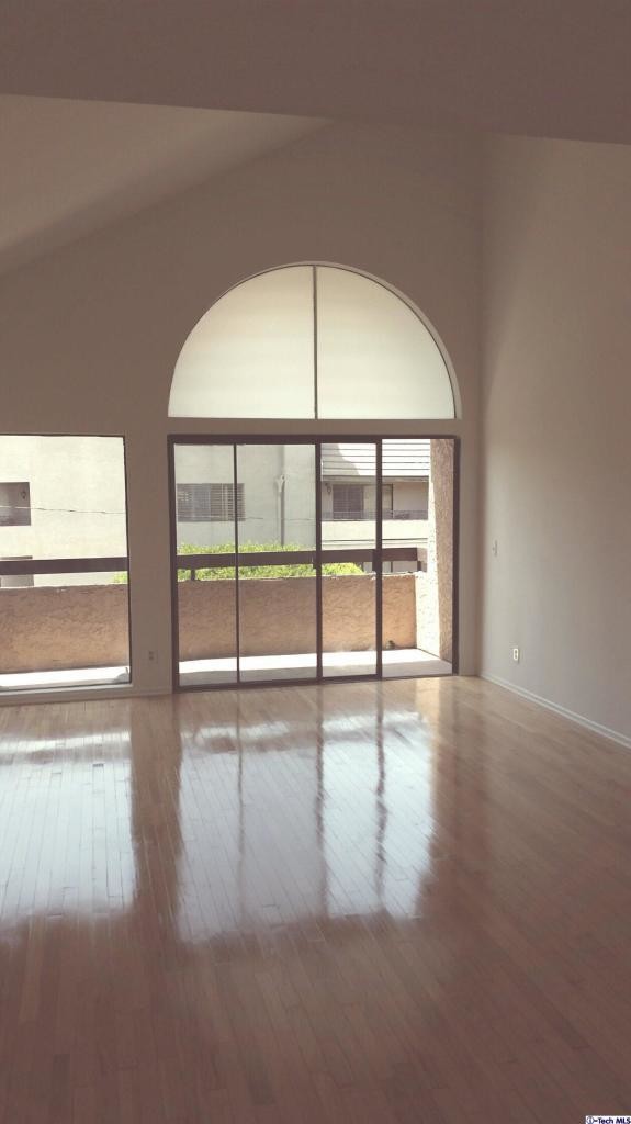 living room with vaulted high ceiling and balcony overlooking the street - 14572 Dickens St
