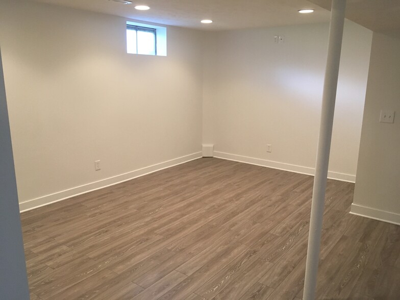 Main basement room showing new quality vynl tile. Would be a great TV room. North wall has a high outlet on wall for big screen TV - 12063 Burdette Cir