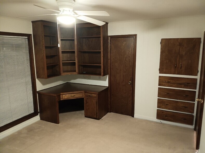 front bedroom 2 built-in desk, shelves, and dresser. middle door goes into walk in closet - 2308 Wesley Cir