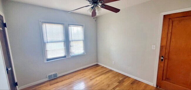 Second main-level bedroom with hardwood flooring, currently used as a fitness room by tenants. - 2923 Arthur St NE