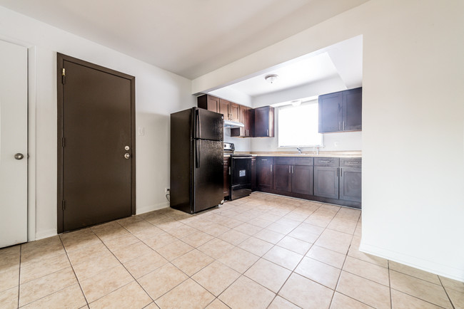 This kitchen at 1121 W 127th St features updated cabinetry and appliances! - 1121 W 127th St