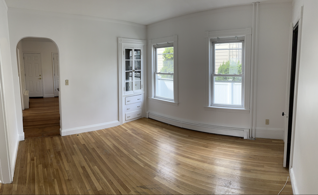 Living area w/ charming built-in cabinet, closet for storage, and natural light - 58 S Waverly St