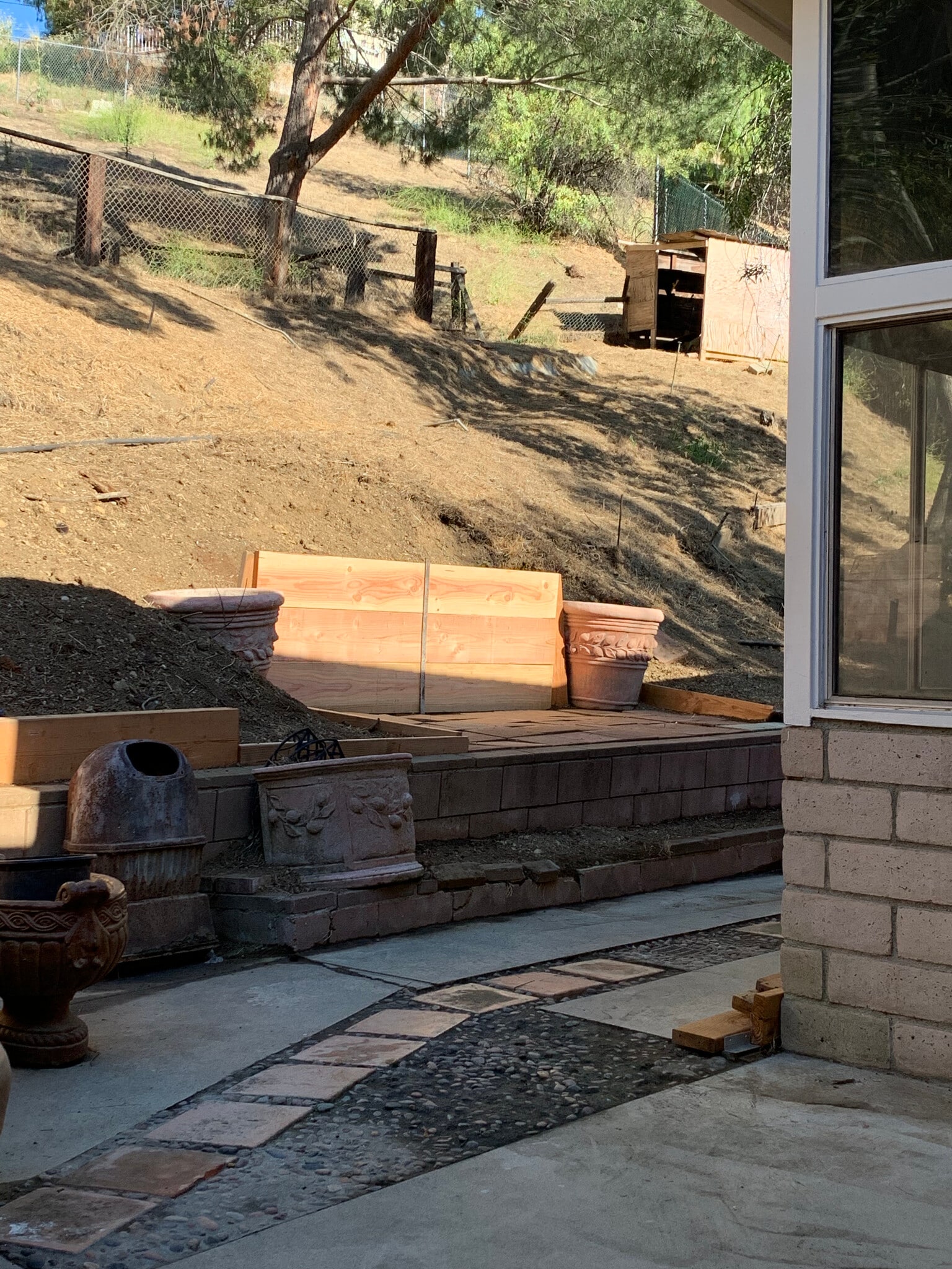 Backyard walkway backs up to a large hillside area, perfect for potentially entertaining with tables - 10458 Pearson Pl