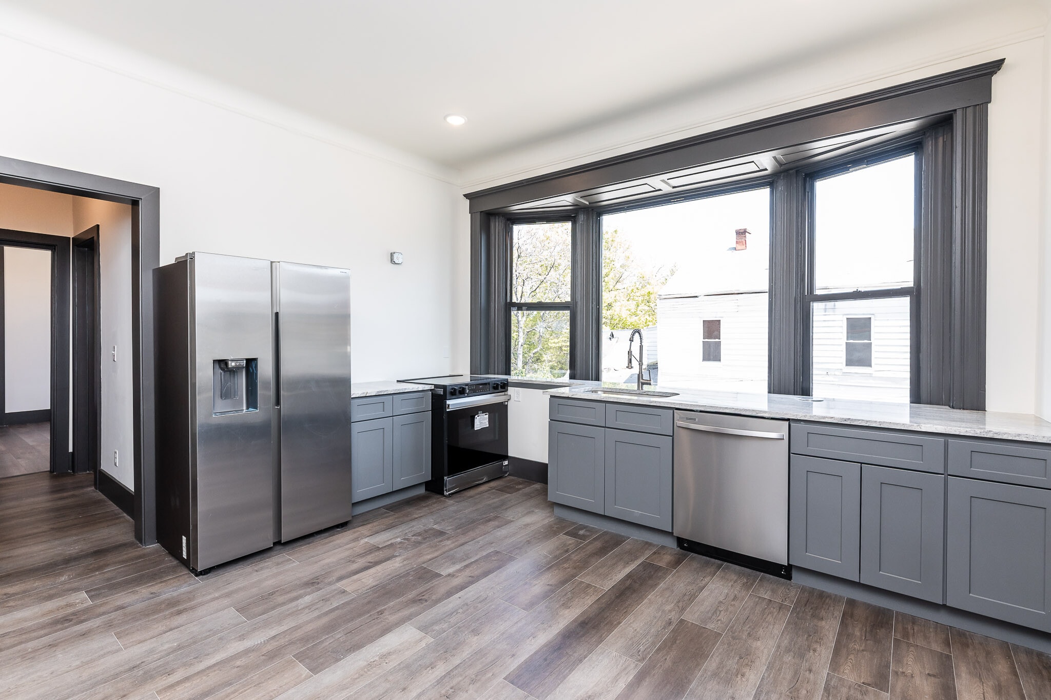 Kitchen has a large bay window, microwave hood has been installed. - 728 E McMillan St