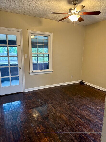 Comfortable bedroom with hardwood floors, natural light, and direct access to the enclosed three-sea - 3682 Glencairn Road