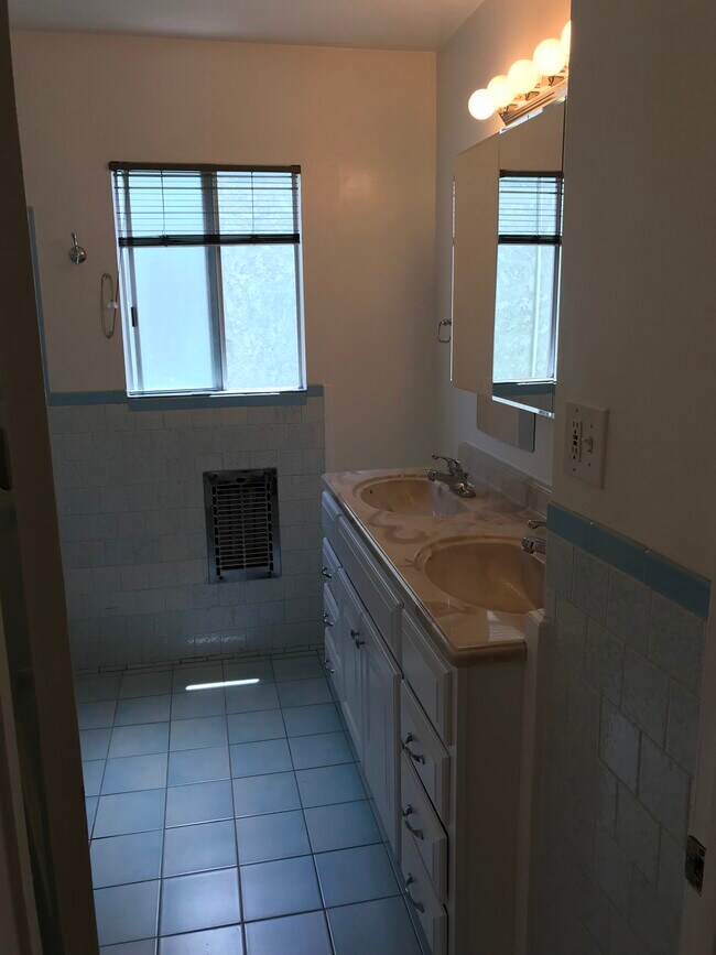 Hallway bath has double vanity, electric heat, tub and shower, and new toilet. - 14911 Fonthill Ave