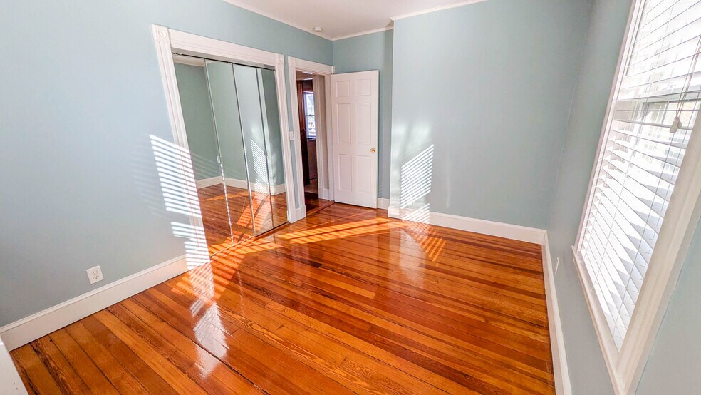 Primary bedroom with hardwood floors, ceiling fan, and ample natural light - 37 Glover Ave