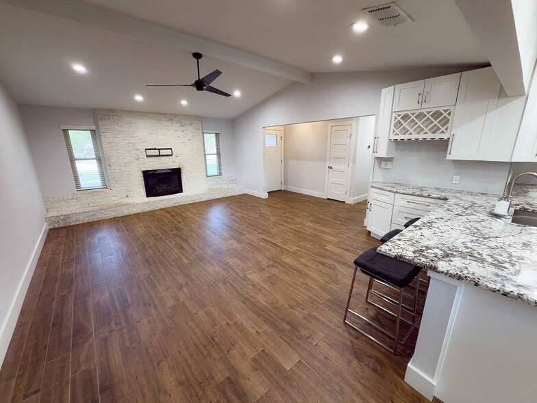 Vaulted ceiling living room with gas fireplace and kitchen island view - 2006 Candle Ct