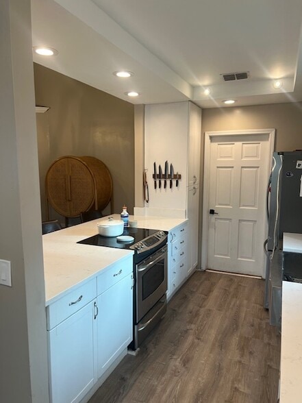 Bright kitchen with white cabinets and open flow to dining. - 953 13th Ave S