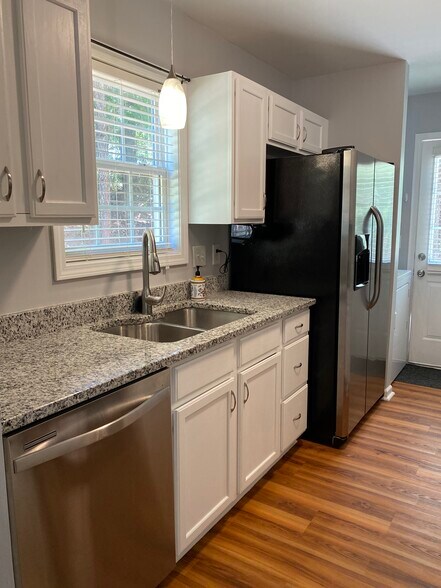 Kitchen has granite counter tops, white cabinets, garbage disposal and stainless appliances including dishwasher and refrigerator. - 1305 Cedar Shoals Drive #500