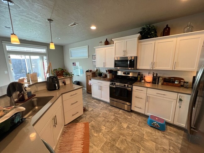 Building Photo - Single level, triple car garage and A/C!