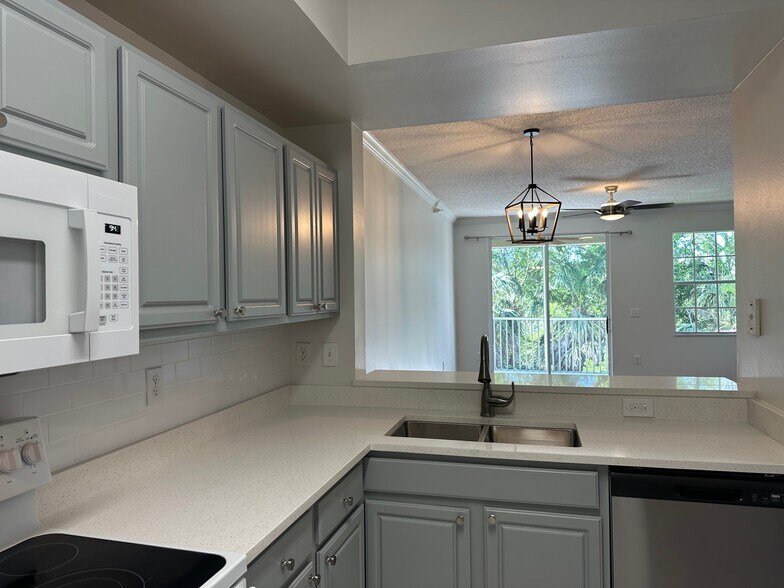 Kitchen with new sink, counters, dishwasher and tropical view - 5701 Bentgrass Dr