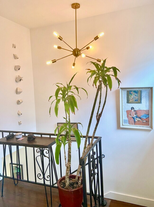 Entry stairwell with starburst gold light fixture and Edison bulbs. - 1672 Rotary Dr