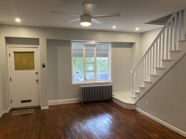 The living room features original, refinished hard wood floors, an open staircase, and a lovely fron - 2621 E Somerset St