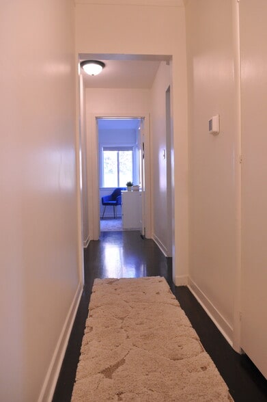 A visual of hallway furnished leading from back bedroom to front bedroom - 4927 Forman Ave