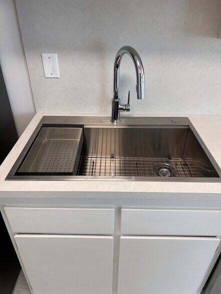 Stainless steel appliances, deep sink, and clean quartz work surfaces. - 11639 Chenault St