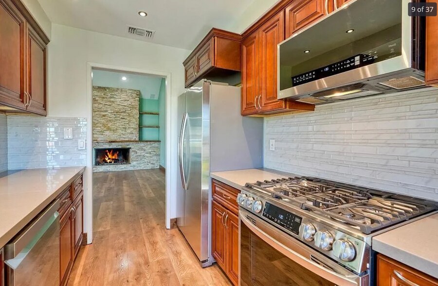 Kitchen with stainless steel appliances and door to patio - 14787 Caminito Orense Oeste