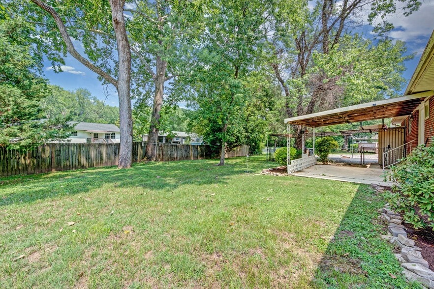 Flat and open back yard with mature trees for shade. - 5017 W Durrett Dr