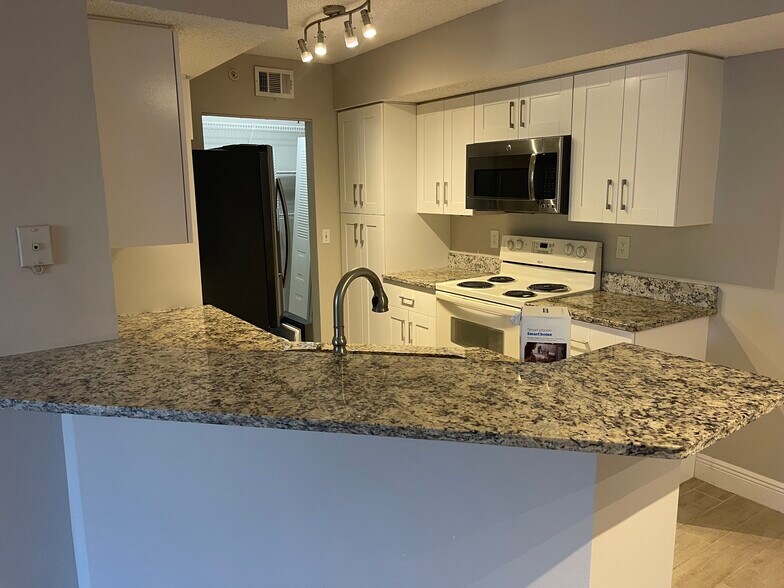 Kitchen with new fridge, stove (not pictured) & microwave - 13561 Eagle Ridge Dr