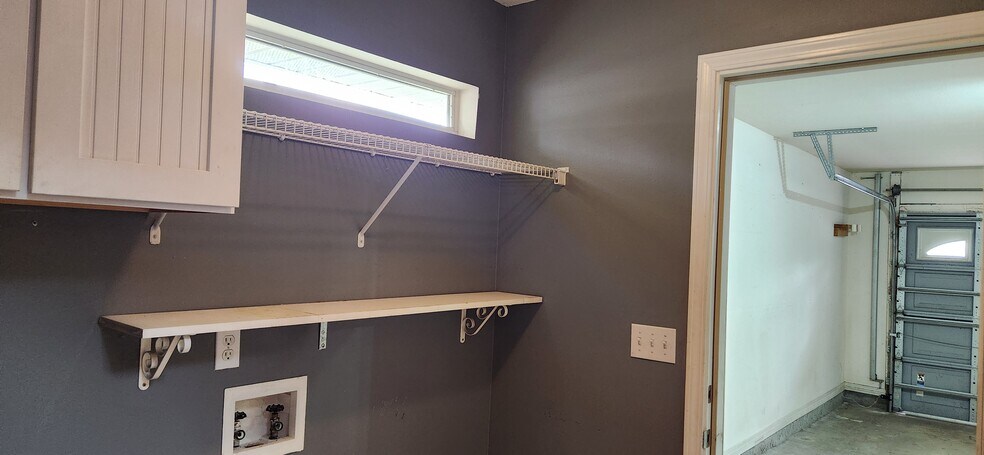 Laundry room with shelves and a cabinet for all the laundry needs - 2318 Tall Oak Dr