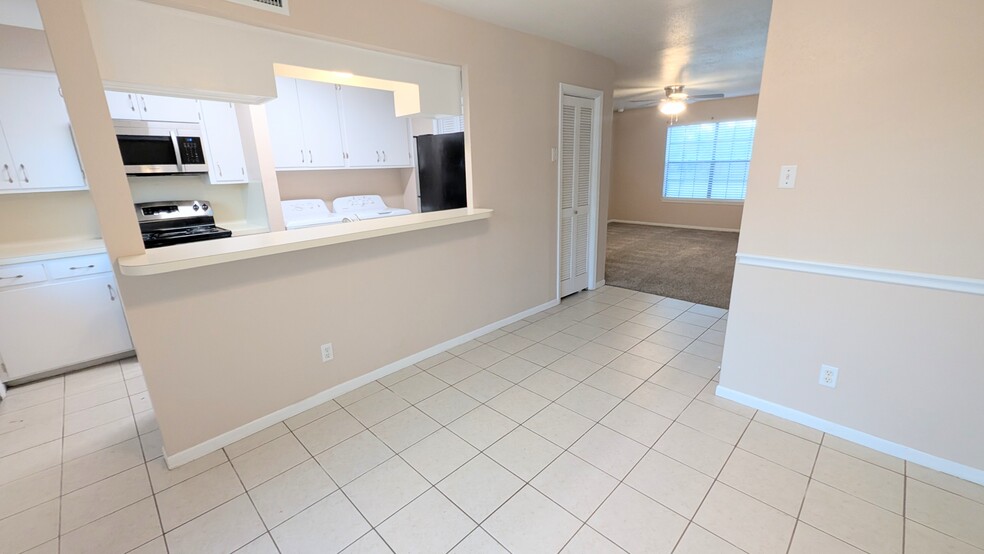 Dining room with kitchen bar, storage closet, and living room. - 813 Clubside Dr