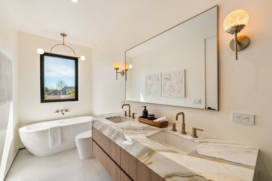 Master bathroom featuring a floating natural stone vanity, freestanding bathtub, and walk-in shower - 836 Waterloo St