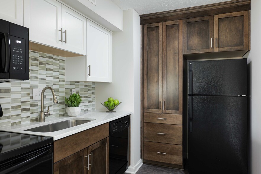 Modern kitchen with custom cabinetry and quartz countertops - The Willows of Plainview