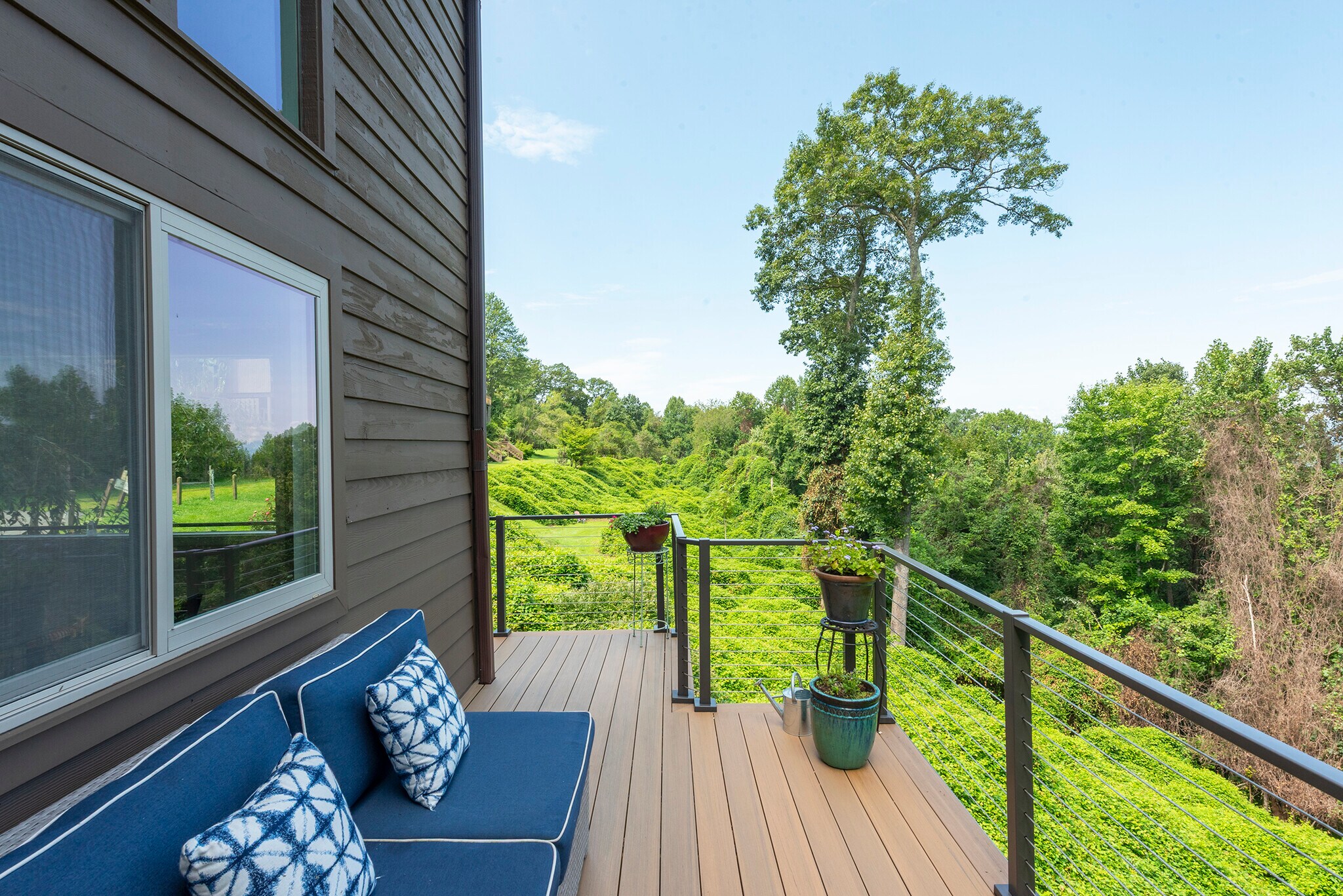 Private, expansive composite deck offering an elevated overlook of the lush surrounding greenery. - 405 Windswept Dr