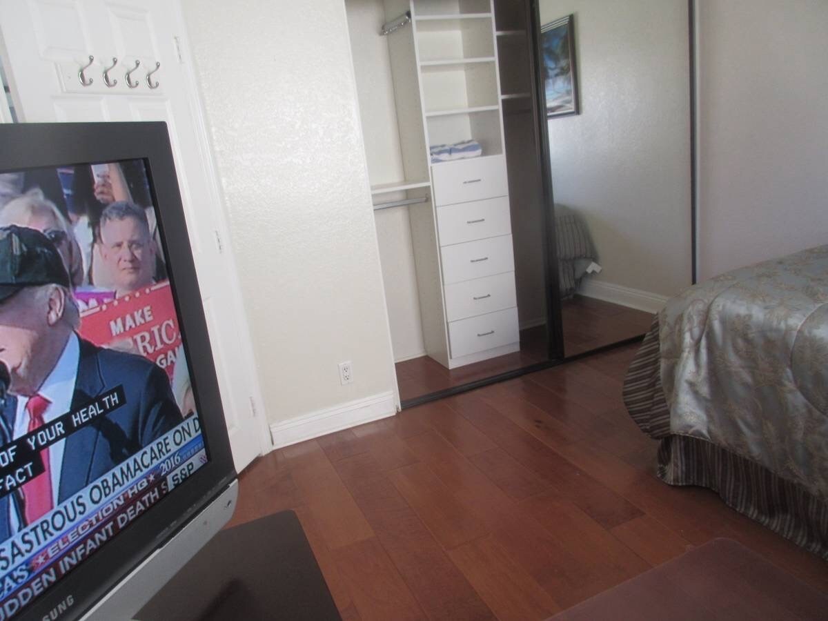 Newer tv on the wall , custom shelves and drawers in closet with 2 mirrors doors - 1400 Pacific Coast Hwy