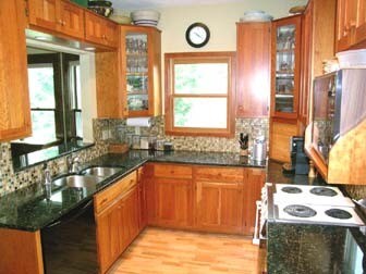 Kitchen with cherry cabinets and black granite countertops. - 2261 Scudder Street