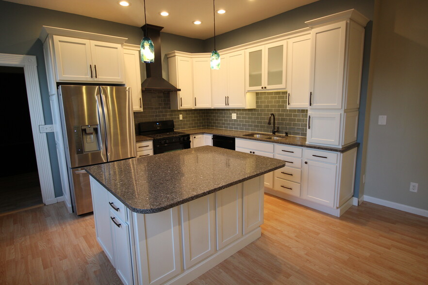 Gorgeous updated kitchen boasting quartz countertop, massive island w/seating, tile, extra tall cabs - 4536 Leo Street