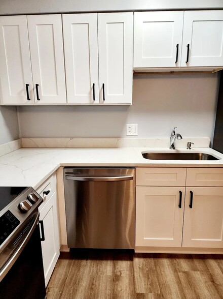 The bright L-shaped kitchen layout offers generous cabinetry, stainless appliances, and stylish fini - 21 Richmond Sq