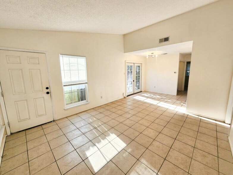 Living room / den area with high ceiling and plenty of natural light. - 111 Meteor Dr
