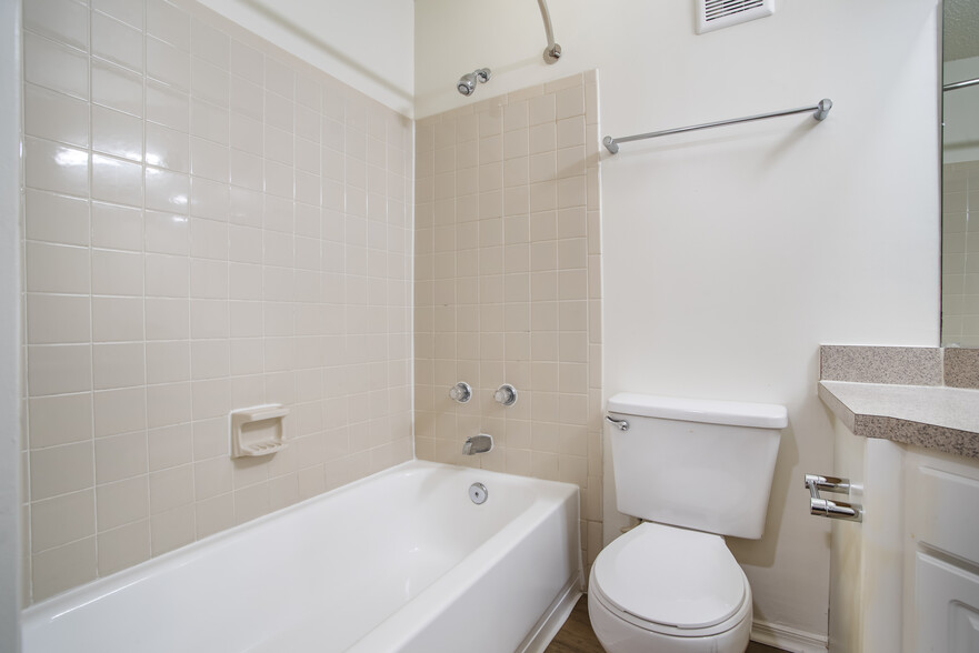 Renovated Package II bath with laminate countertops, white cabinetry, and hard surface flooring - eaves Fair Lakes