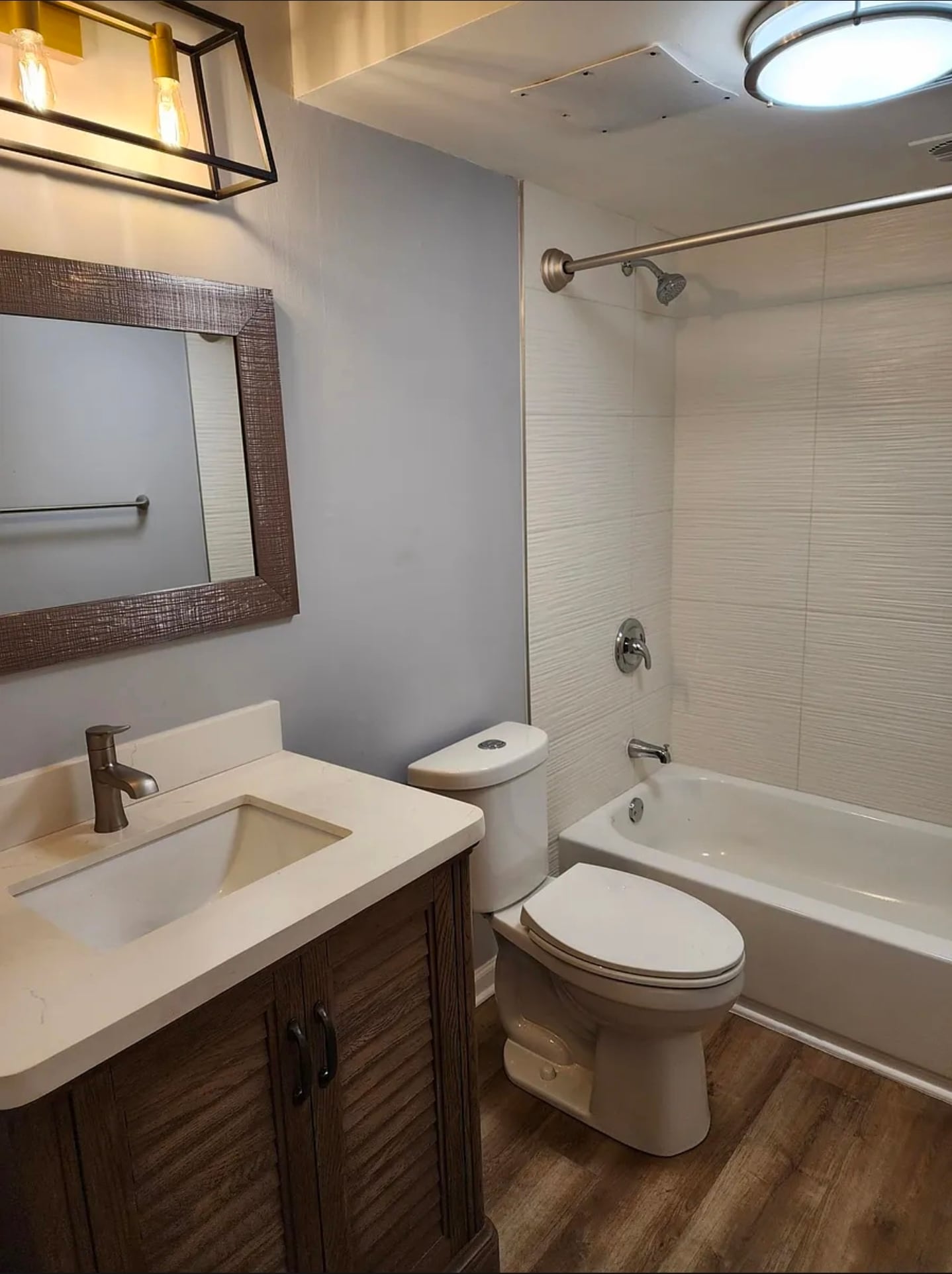 The updated bathroom includes a tiled shower surround, modern fixtures, and a clean, neutral design. - 21 Richmond Sq