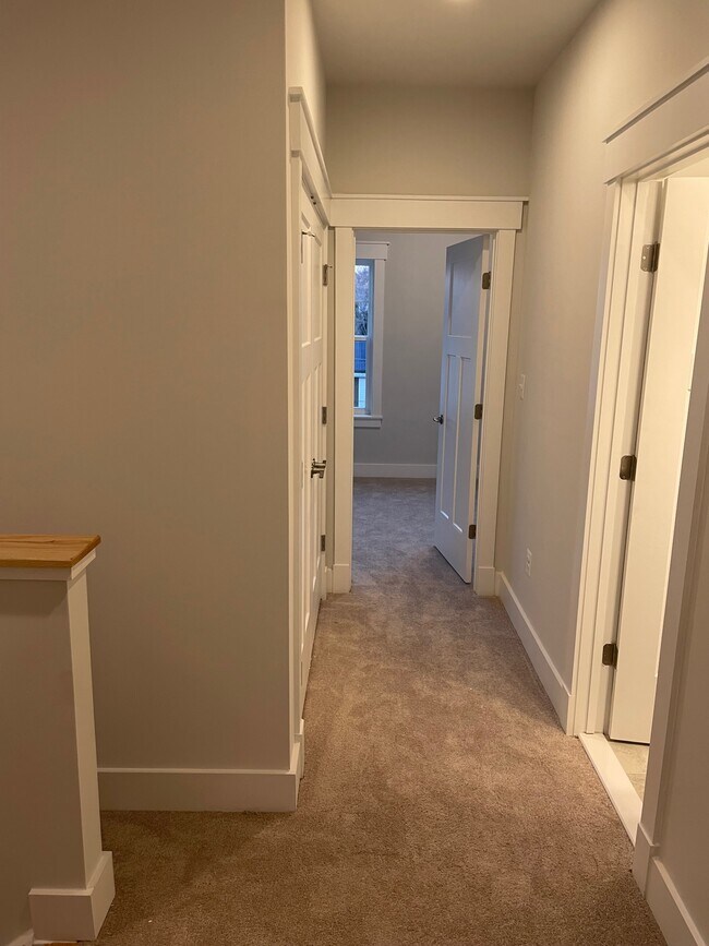 Upstairs hallway with view of bedoom 1, bathroom, and washer/dryer closet - 1310 Cougar Ln
