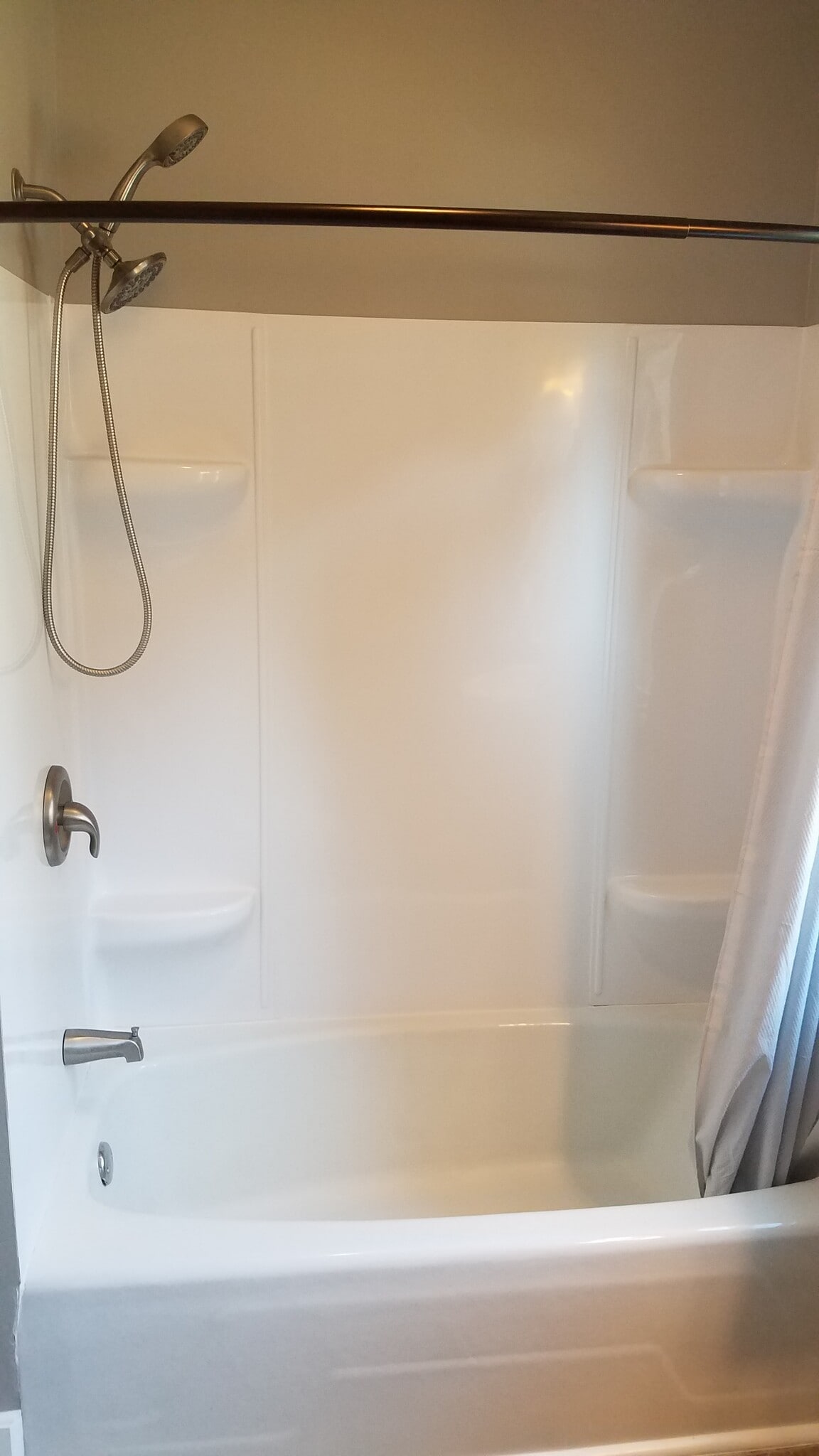 Modern tub and surround with Moen fixtures and permanently mounted curved shower rod - 2104 Folger Ct